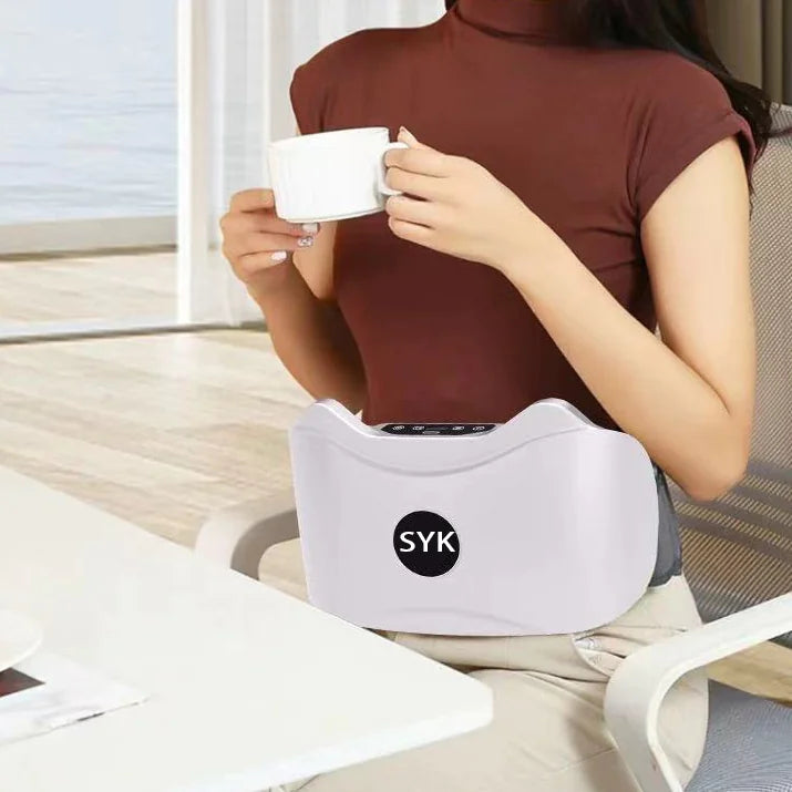 Person using a white massage belt with SYK logo while holding a mug.