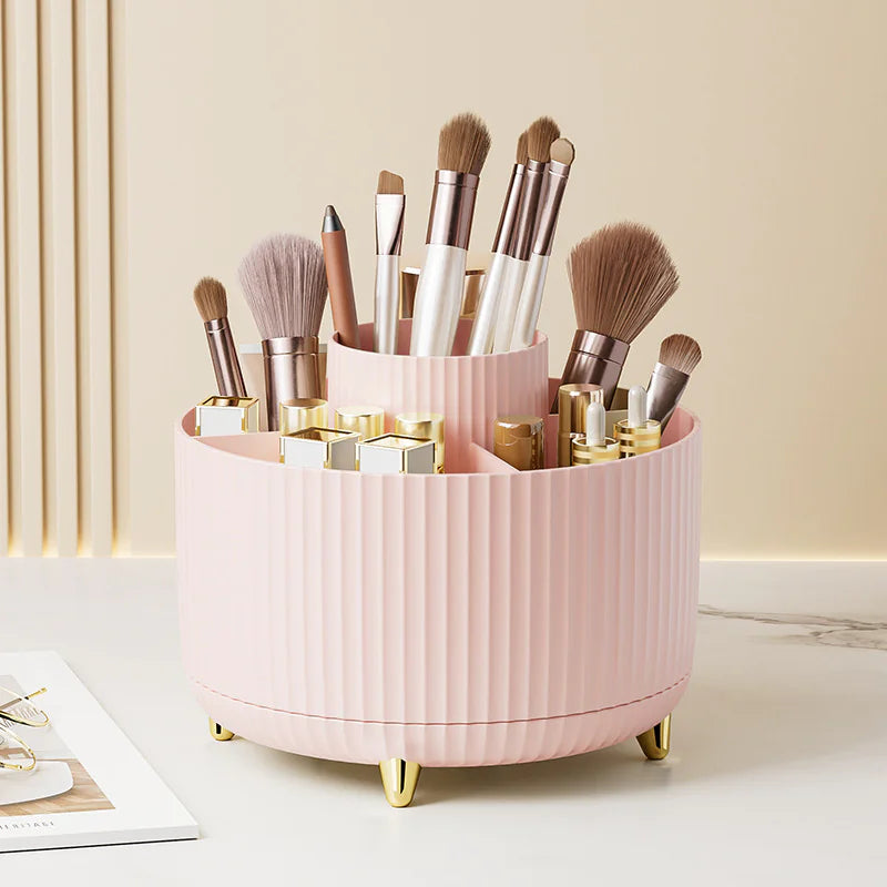 Pink makeup brush holder with various brushes on a light surface.