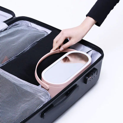 Person placing a pink electronic device into a black travel case with compartments.
