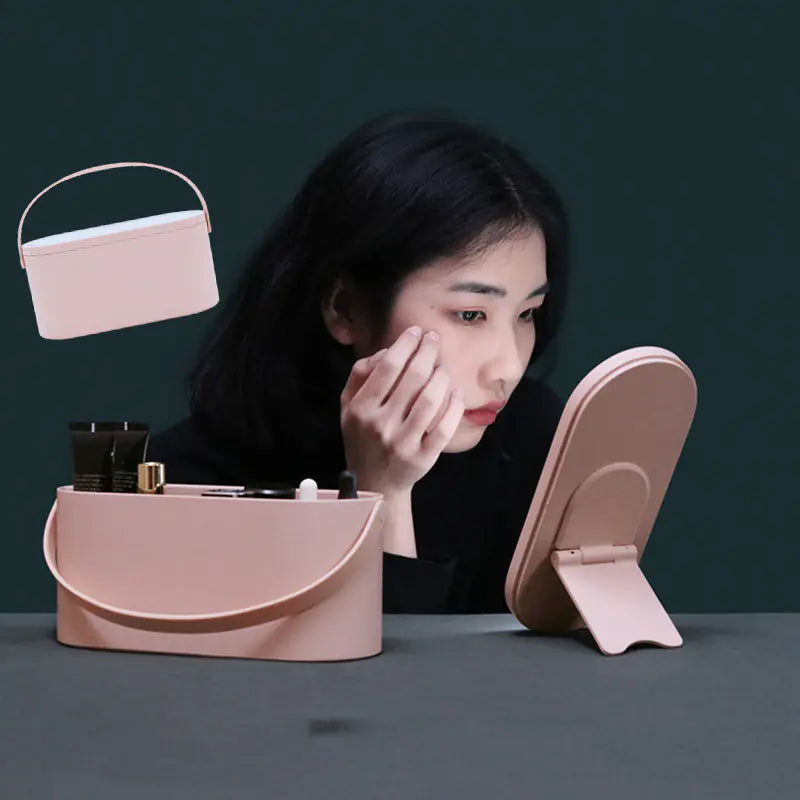 Woman applying makeup in front of a pink vanity mirror and case on a dark background