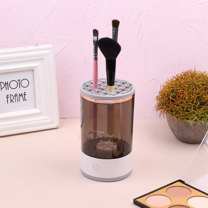 Makeup brush holder with brushes on a desk next to a photo frame and plant