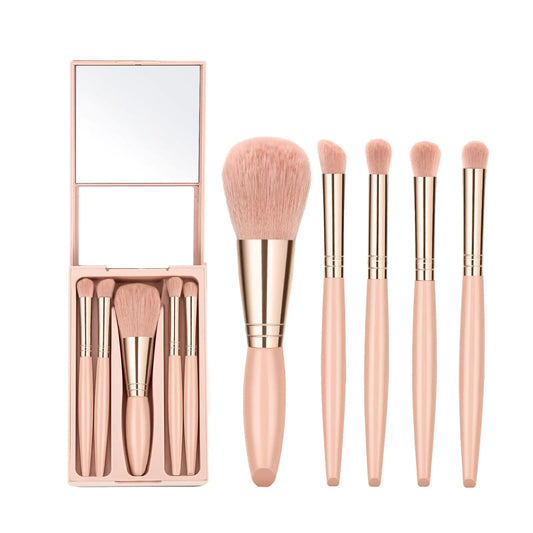 Set of makeup brushes with a rose gold handle and pink bristles, including a mirror, on a white background.