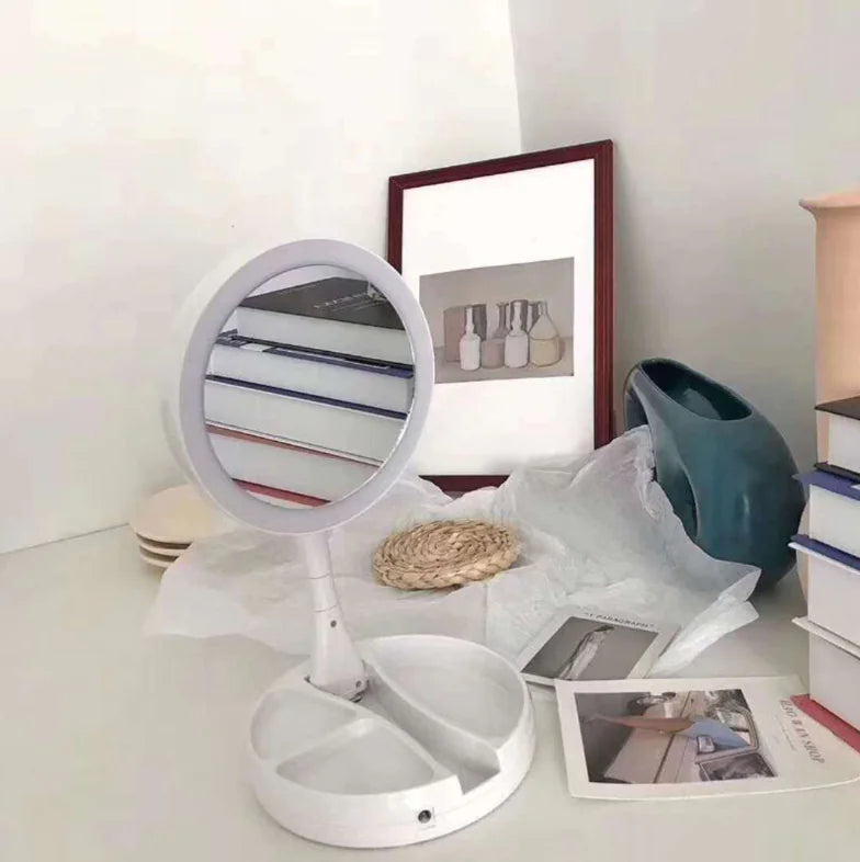 White vanity mirror on a desk with books and decorative items in the background